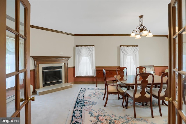 dining area with a wealth of natural light, ornamental molding, and a chandelier