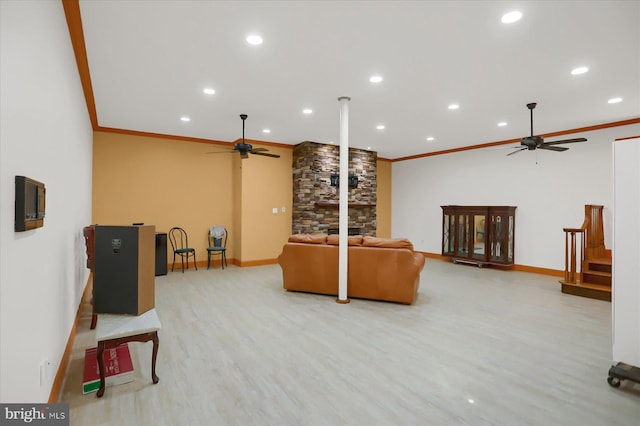 living room with a fireplace, ornamental molding, and light wood-type flooring