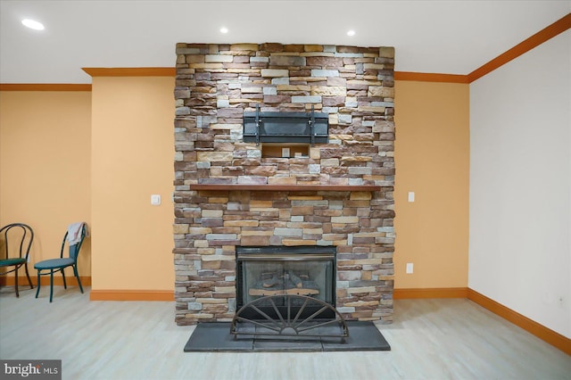 details featuring crown molding, a fireplace, and hardwood / wood-style floors