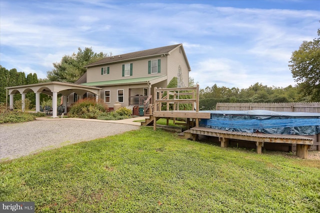 back of house featuring a yard and a covered pool