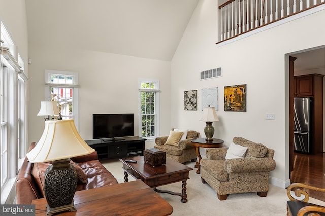 living room featuring carpet flooring and high vaulted ceiling