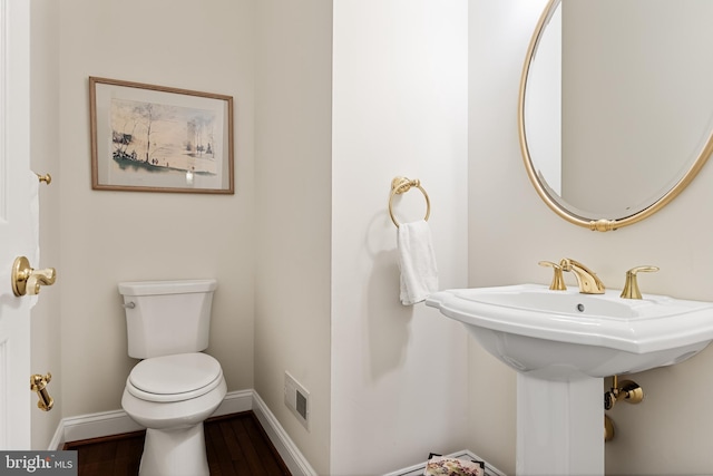 bathroom with hardwood / wood-style floors and toilet