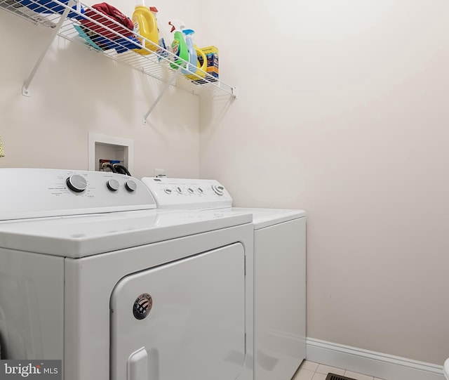 washroom featuring light tile patterned flooring and washing machine and clothes dryer