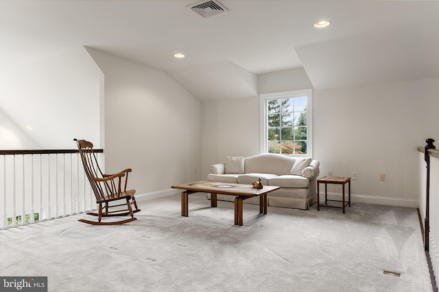 living area with lofted ceiling and light carpet