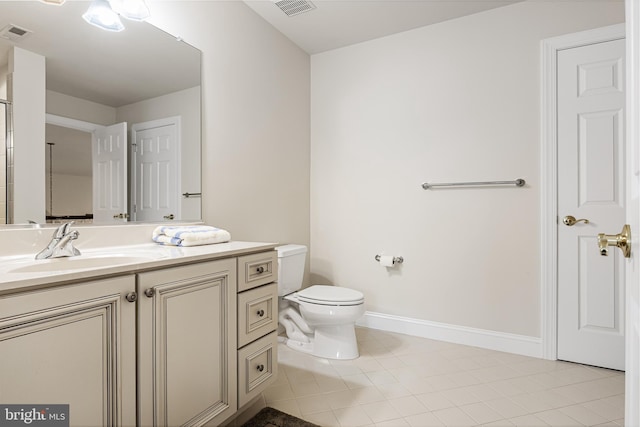 bathroom featuring tile patterned flooring, vanity, and toilet