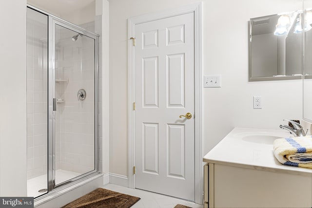 bathroom featuring tile patterned flooring, vanity, and a shower with shower door