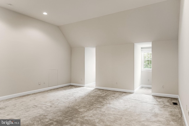 carpeted empty room featuring lofted ceiling