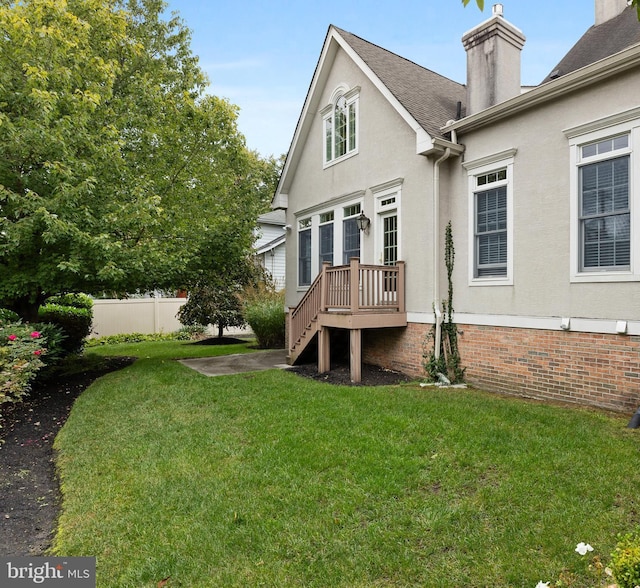 back of house featuring a deck and a yard