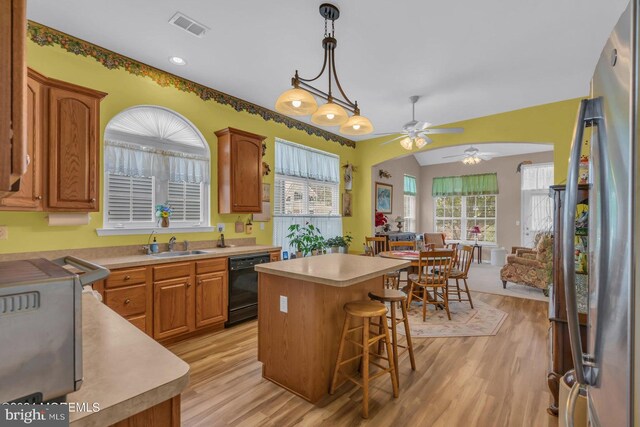 kitchen featuring a kitchen island, dishwasher, light hardwood / wood-style flooring, decorative light fixtures, and ceiling fan