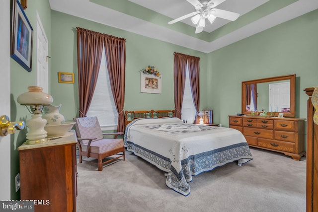 carpeted bedroom featuring multiple windows and ceiling fan