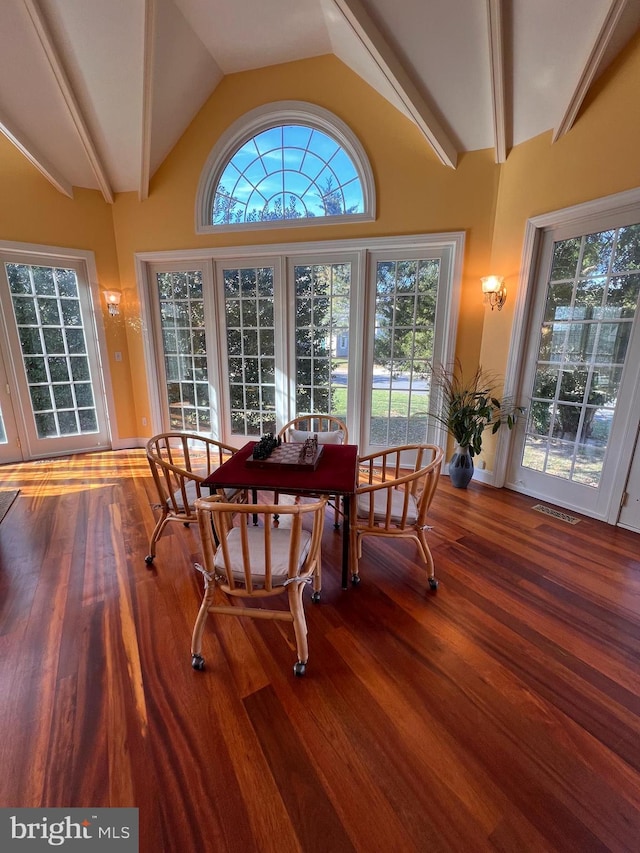 dining space featuring wood-type flooring and lofted ceiling with beams