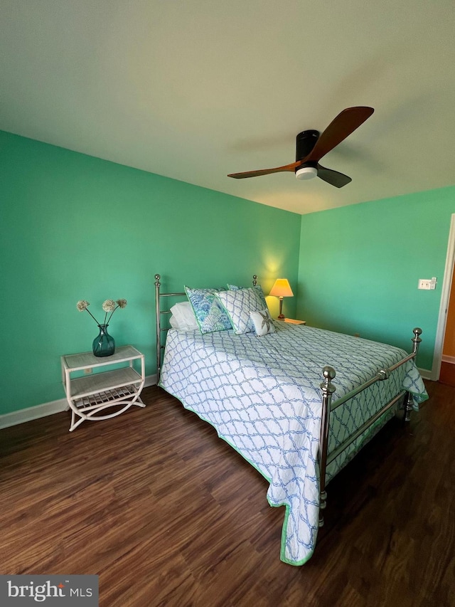 bedroom with dark hardwood / wood-style flooring and ceiling fan