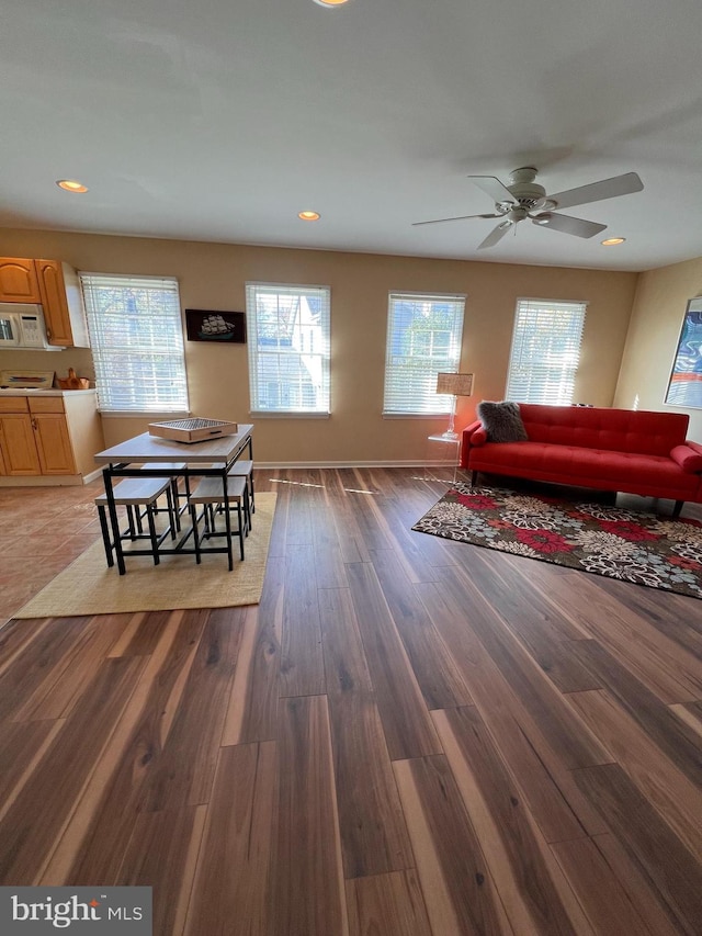 living room featuring dark hardwood / wood-style flooring and ceiling fan