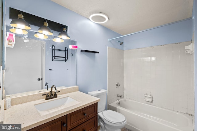 full bathroom featuring vanity, toilet, a textured ceiling, and tiled shower / bath