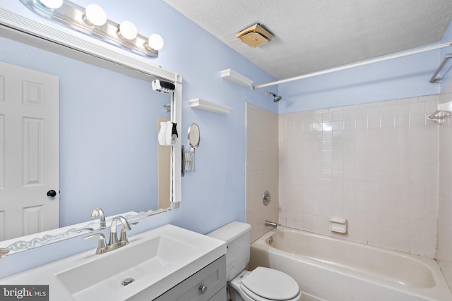 full bathroom featuring vanity, tiled shower / bath combo, a textured ceiling, and toilet