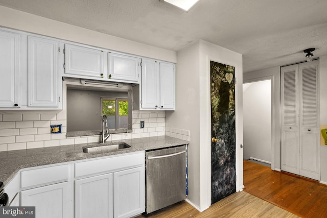 kitchen with decorative backsplash, white cabinets, light hardwood / wood-style flooring, dishwasher, and sink