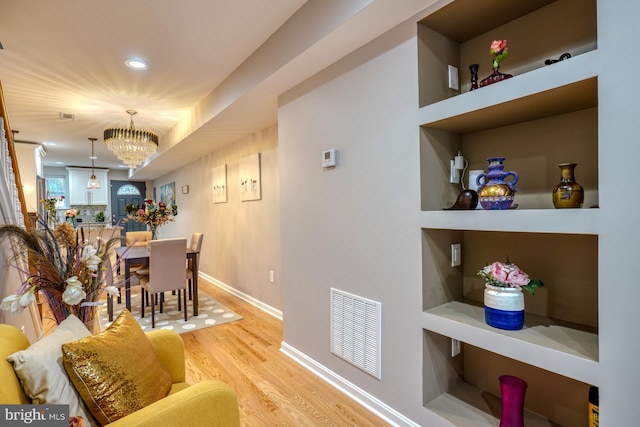 dining area with light hardwood / wood-style flooring and a notable chandelier