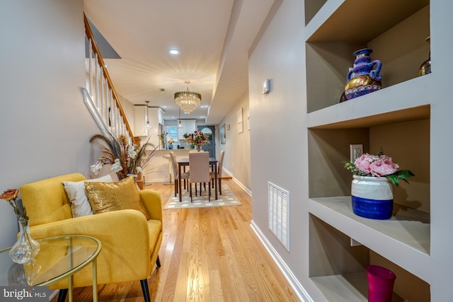 corridor featuring a notable chandelier and light hardwood / wood-style floors