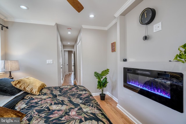 bedroom with crown molding, light hardwood / wood-style flooring, and ceiling fan