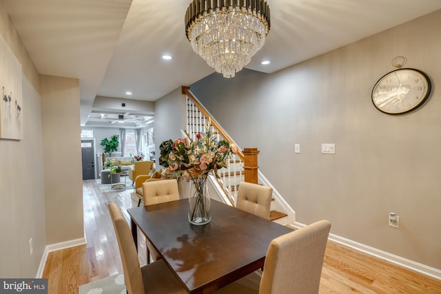 dining room with light hardwood / wood-style flooring and an inviting chandelier