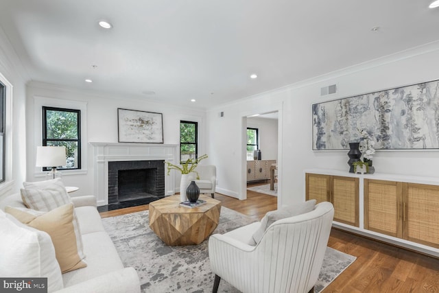 6019 Utah Ave NW, Washington, DC 20015 - living room featuring healthy amount of natural light, ornamental molding, wood finished floors, a brick fireplace, and recessed lighting