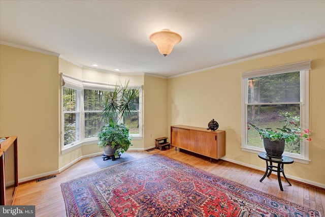 sitting room with light hardwood / wood-style floors and ornamental molding