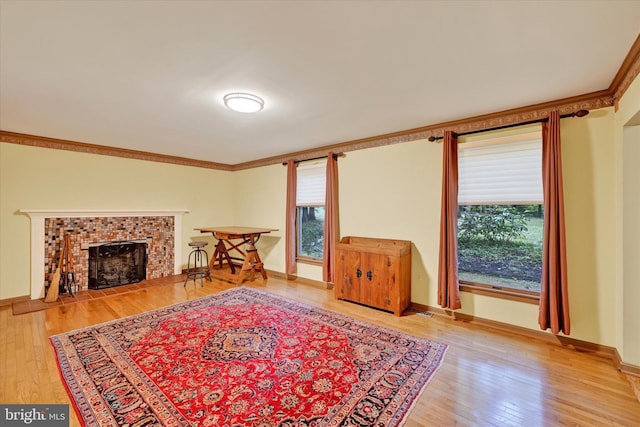 living room featuring hardwood / wood-style flooring, crown molding, and a tile fireplace