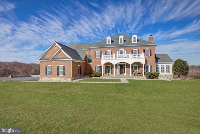 view of front of house featuring a balcony, a front lawn, and covered porch