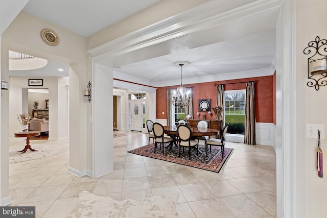 dining room with crown molding, light tile patterned flooring, and an inviting chandelier