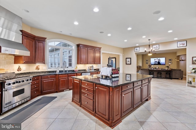 kitchen featuring sink, hanging light fixtures, wall chimney range hood, luxury stove, and light tile patterned flooring