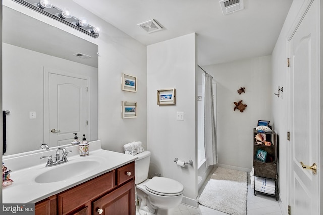 bathroom with tile patterned flooring, vanity, toilet, and walk in shower