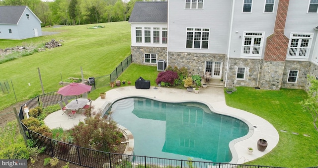 view of swimming pool with a patio area, a yard, and cooling unit