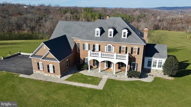 back of property with a patio area, a balcony, and a yard