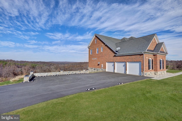 view of side of property featuring a yard and a garage