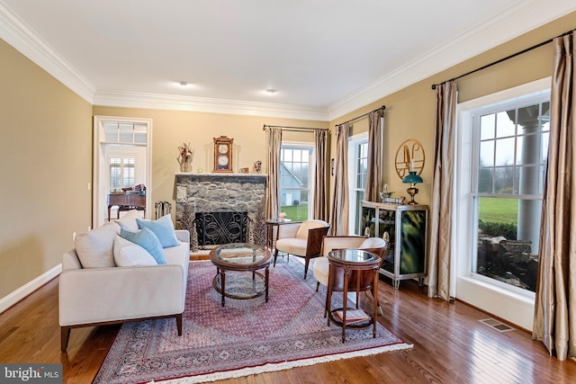 living room featuring a stone fireplace, dark hardwood / wood-style flooring, and ornamental molding