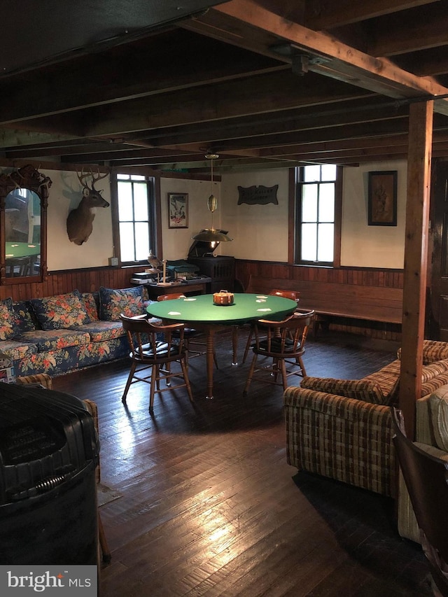 playroom with wood walls, beamed ceiling, and wood-type flooring