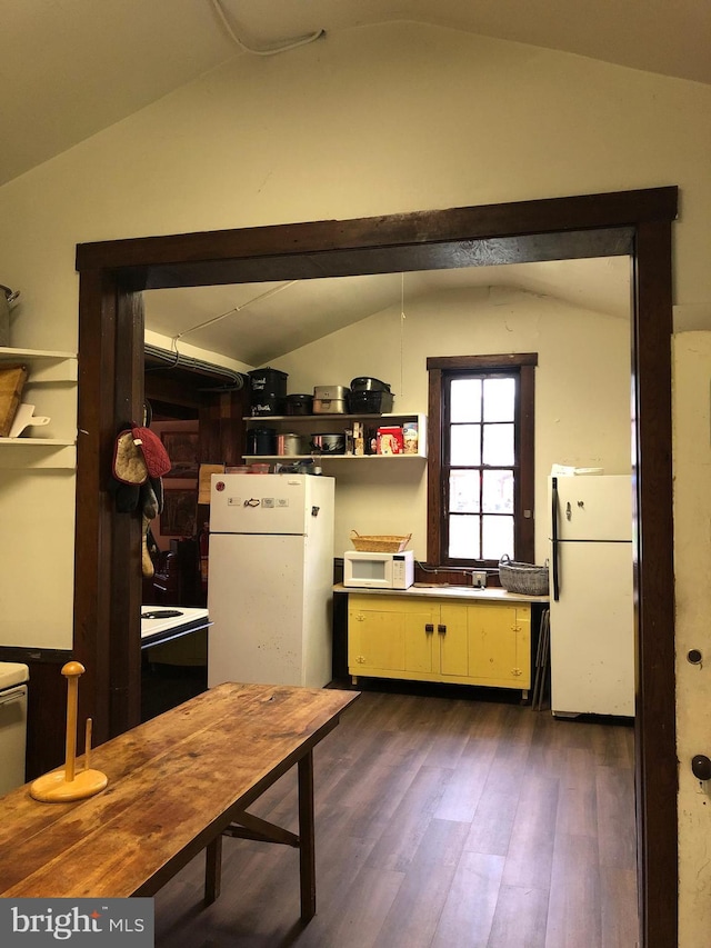 kitchen with white appliances, dark wood-type flooring, and lofted ceiling