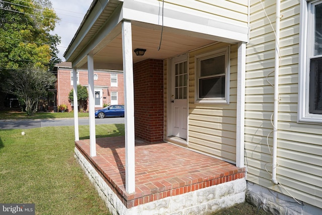 doorway to property with a lawn