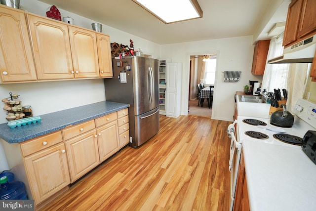 kitchen with a wealth of natural light, white electric range oven, light hardwood / wood-style flooring, and stainless steel refrigerator