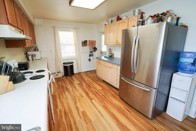 kitchen with white electric range oven, stainless steel fridge, and light hardwood / wood-style floors