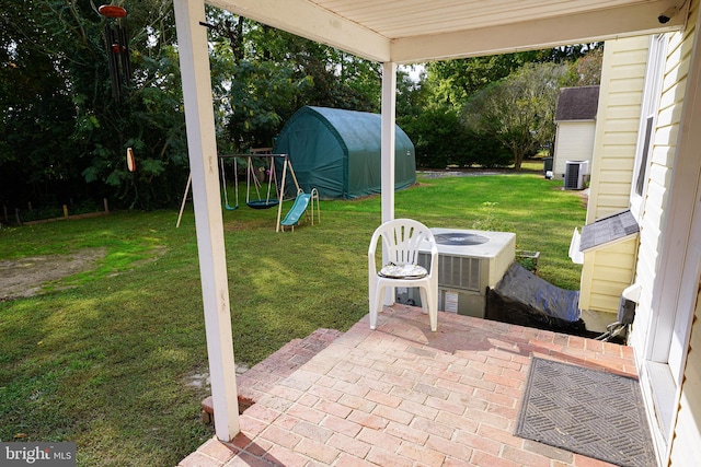 view of patio / terrace featuring central air condition unit, a storage shed, and a playground