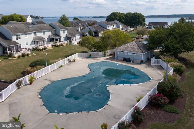 view of swimming pool featuring a patio, a yard, and a water view