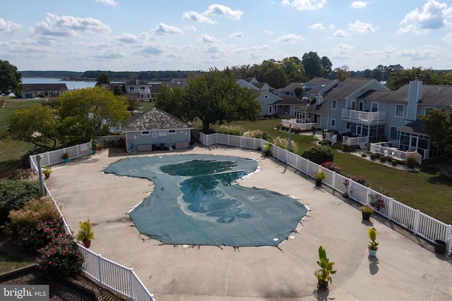 view of pool featuring a water view and a patio