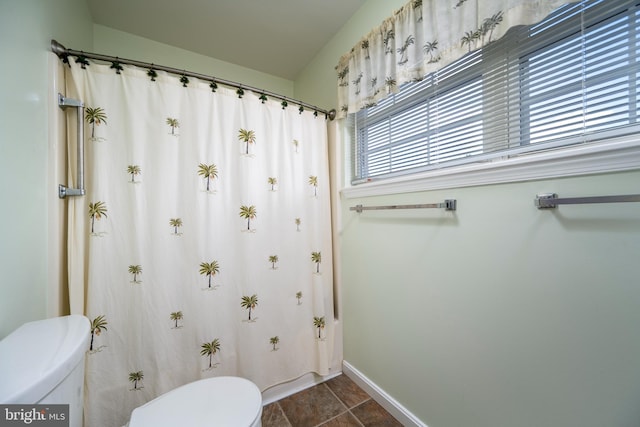 bathroom with tile patterned floors, toilet, and a shower with shower curtain