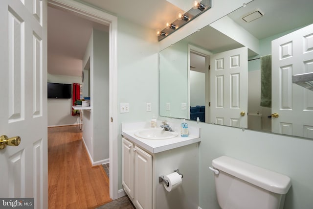 bathroom featuring vanity, hardwood / wood-style floors, and toilet