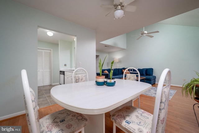 dining space featuring ceiling fan, vaulted ceiling, and light hardwood / wood-style floors