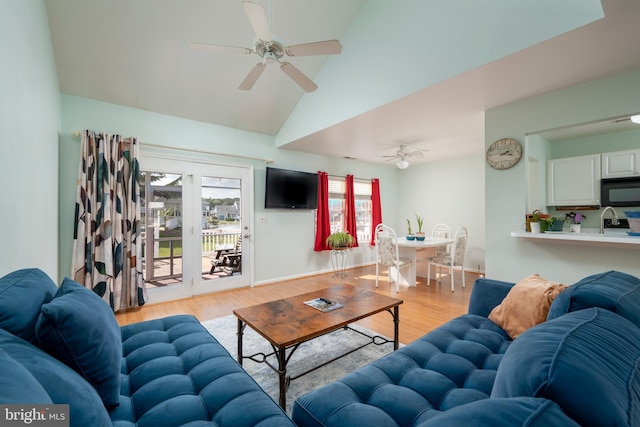 living room featuring sink, high vaulted ceiling, light hardwood / wood-style flooring, and ceiling fan