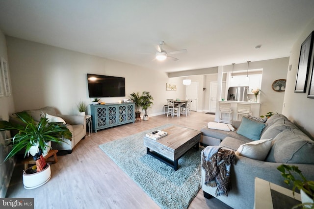 living room with ceiling fan and hardwood / wood-style flooring