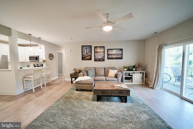 living room featuring ceiling fan and light hardwood / wood-style floors