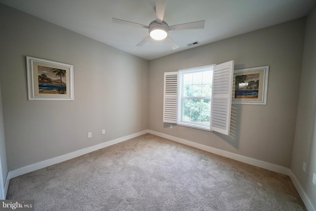 carpeted spare room featuring ceiling fan